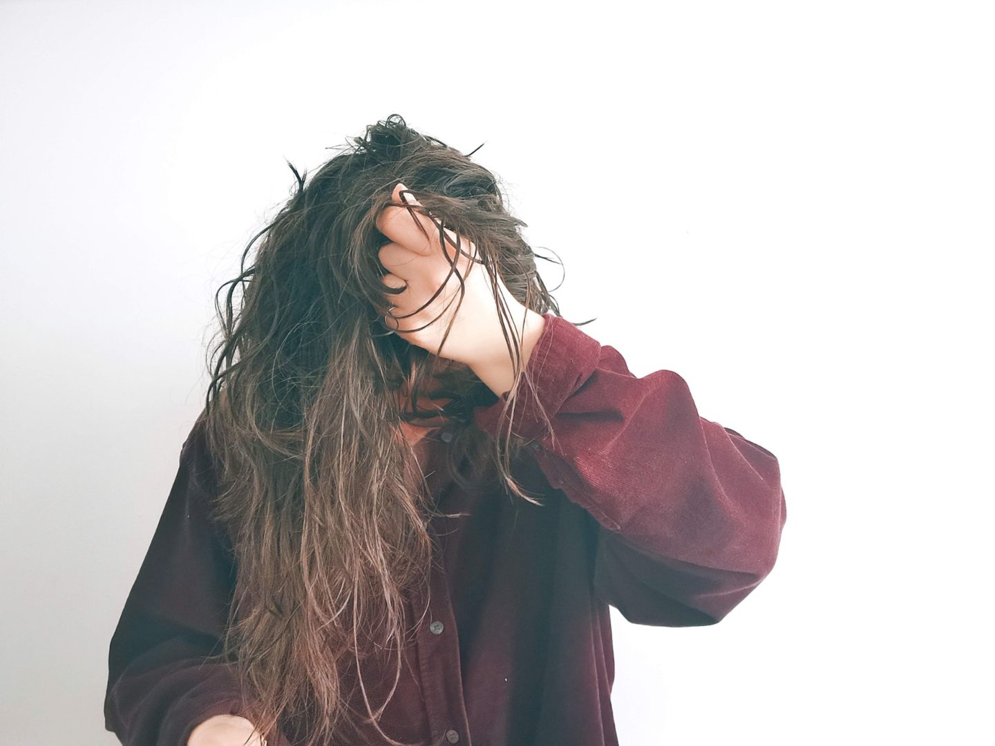 girl tipping her hair over and scrunching out the crunch of gel for the curly girl method